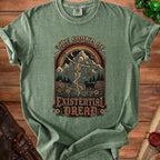 Green t-shirt with graphic of dancing skeleton, mountains, and text "The Sound of Existential Dread."