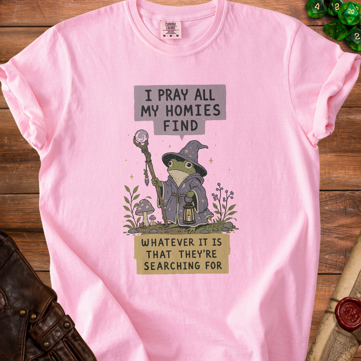 Pink t-shirt with wizard frog graphic and text "I PRAY ALL MY HOMIES FIND WHATEVER IT IS THAT THEY'RE SEARCHING FOR".