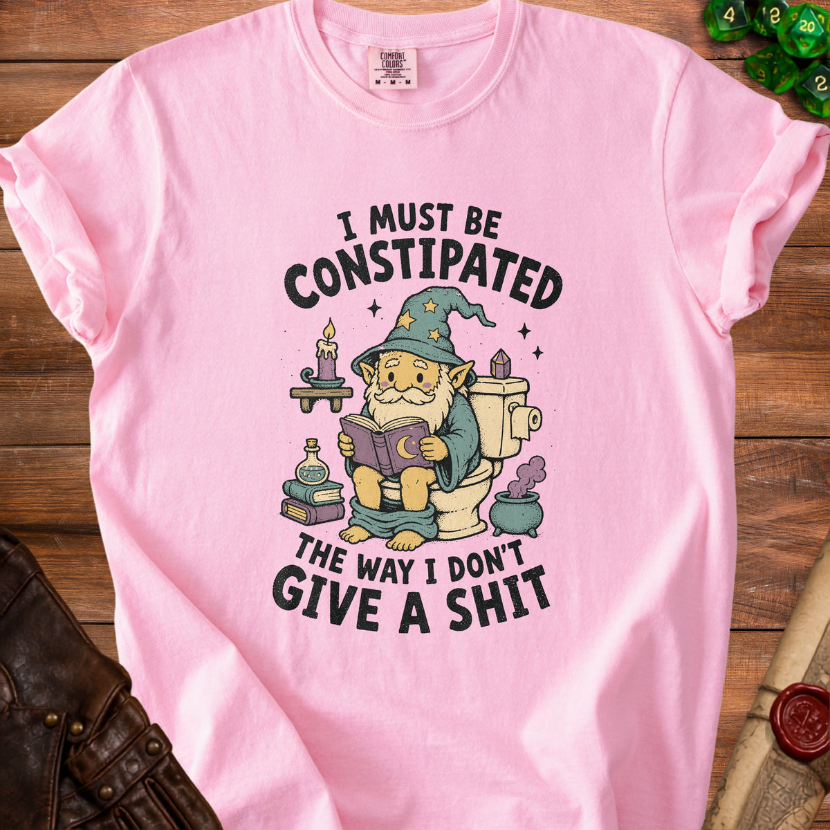 Pink t-shirt with gnome on toilet reading, "I must be constipated the way I don't give a shit."