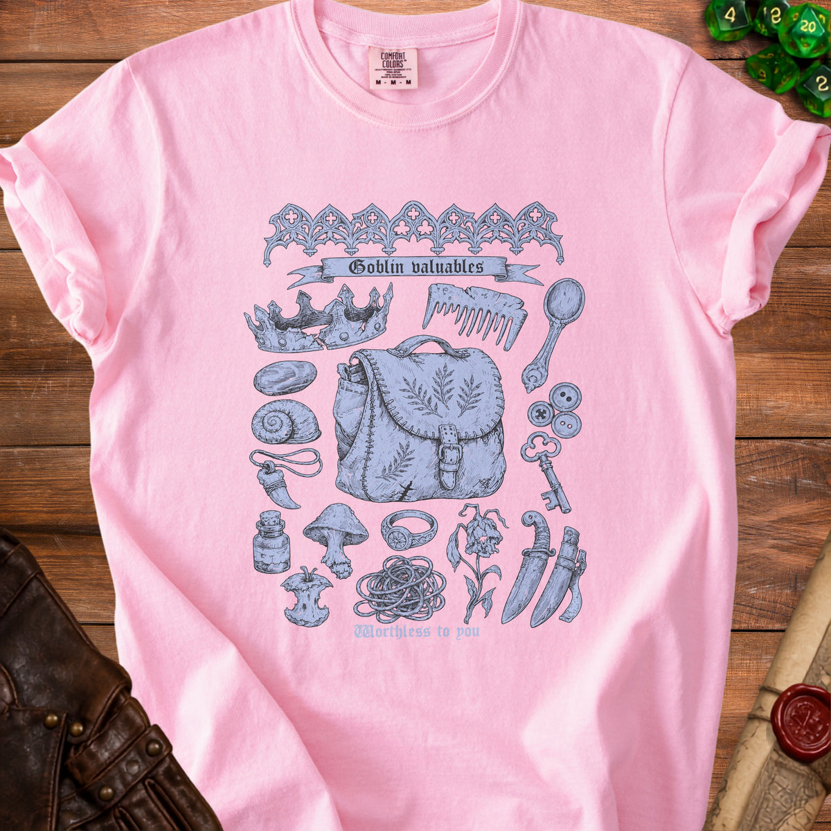 Pink t-shirt with "Goblin valuables" and assorted trinkets print, including a crown and bag.