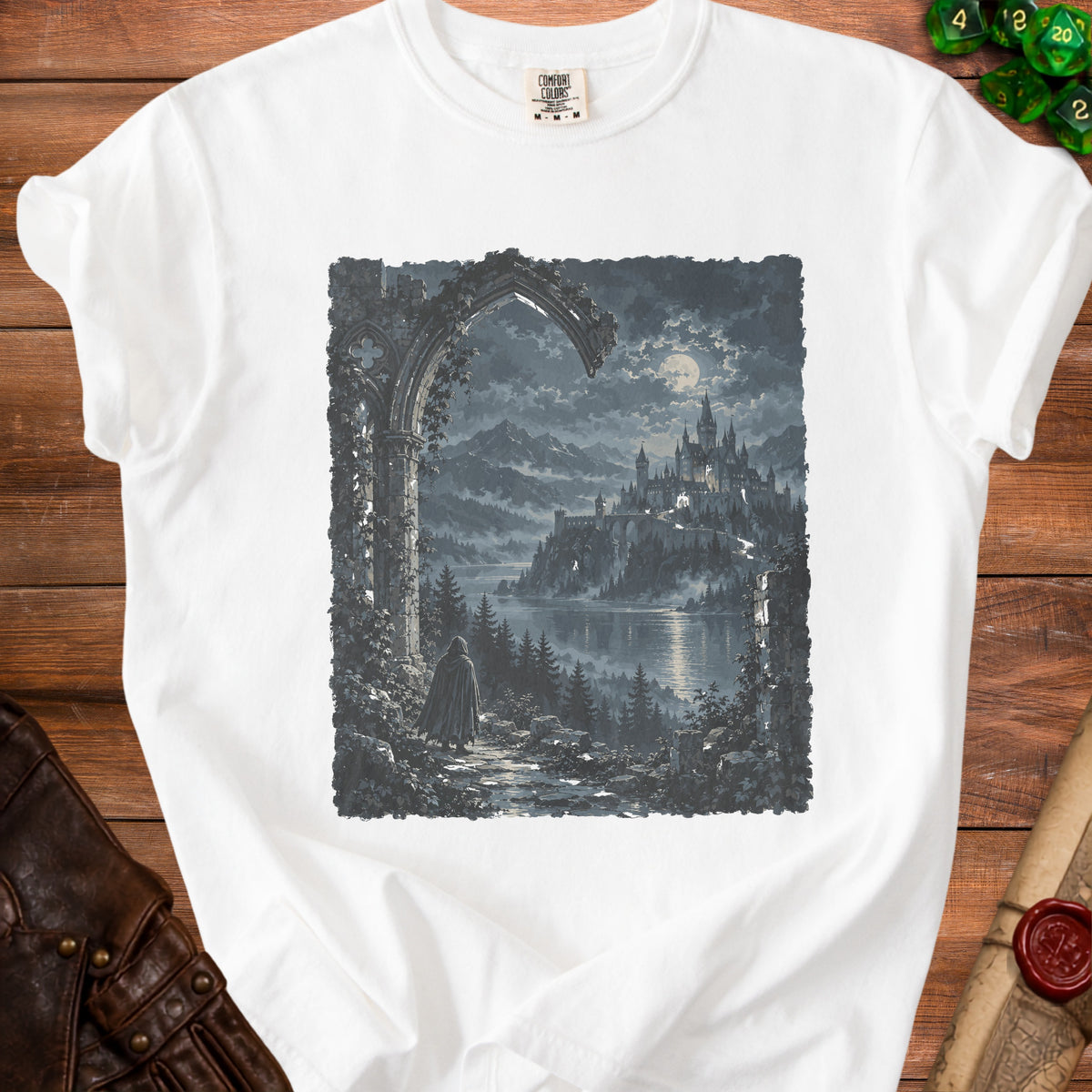 White t-shirt with a dark fantasy print of a cloaked figure facing a castle by a lake.
