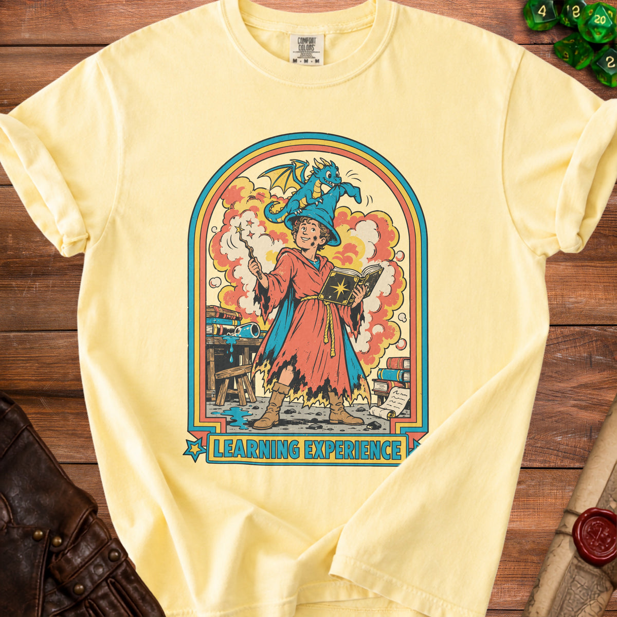 Yellow t-shirt with illustration of wizard, dragon, and "Learning Experience" text.