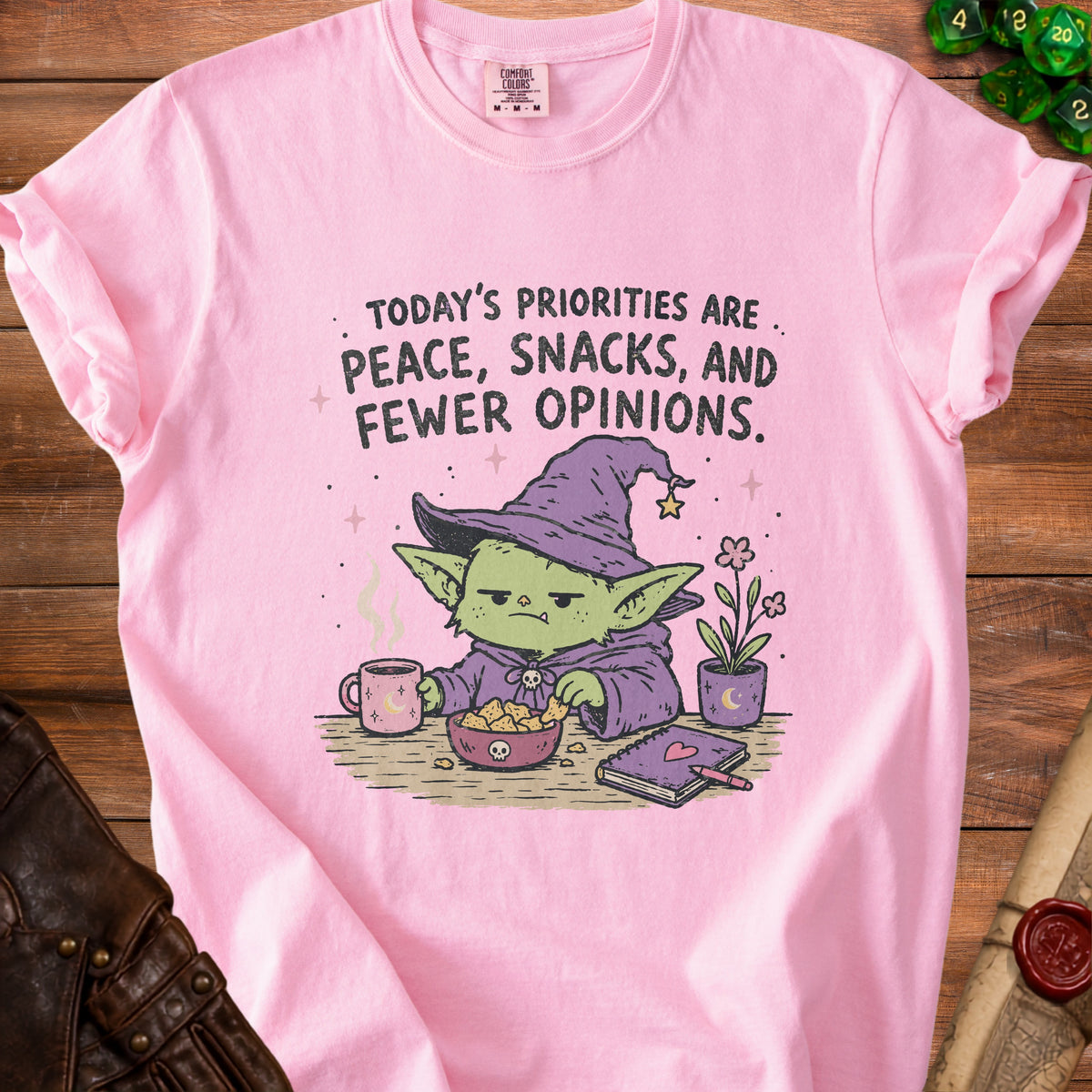 Pink t-shirt with graphic: "Today's Priorities Are Peace, Snacks, and Fewer Opinions."