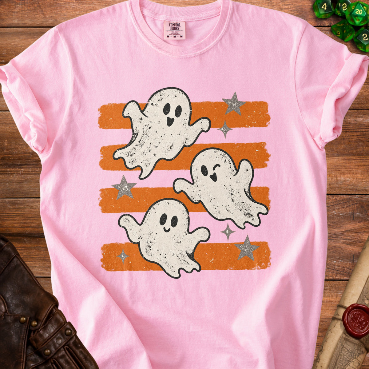 Pink t-shirt with three cartoon ghosts and orange stripes.