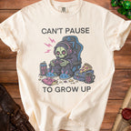 Cream t-shirt with Grim Reaper gaming, pizza, chips, and text "Can't Pause To Grow Up".
