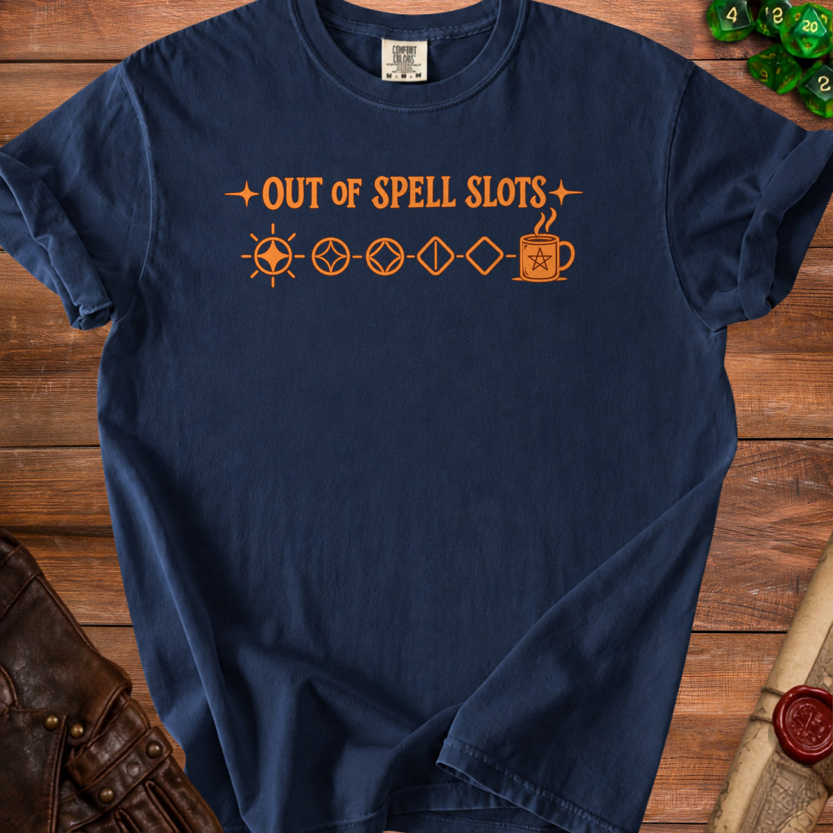 Navy blue t-shirt featuring orange text reading OUT OF SPELL SLOTS and RPG dice icons on wood background.