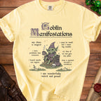 Yellow t-shirt with "Goblin Manifestations" text and illustration of a goblin with coins.