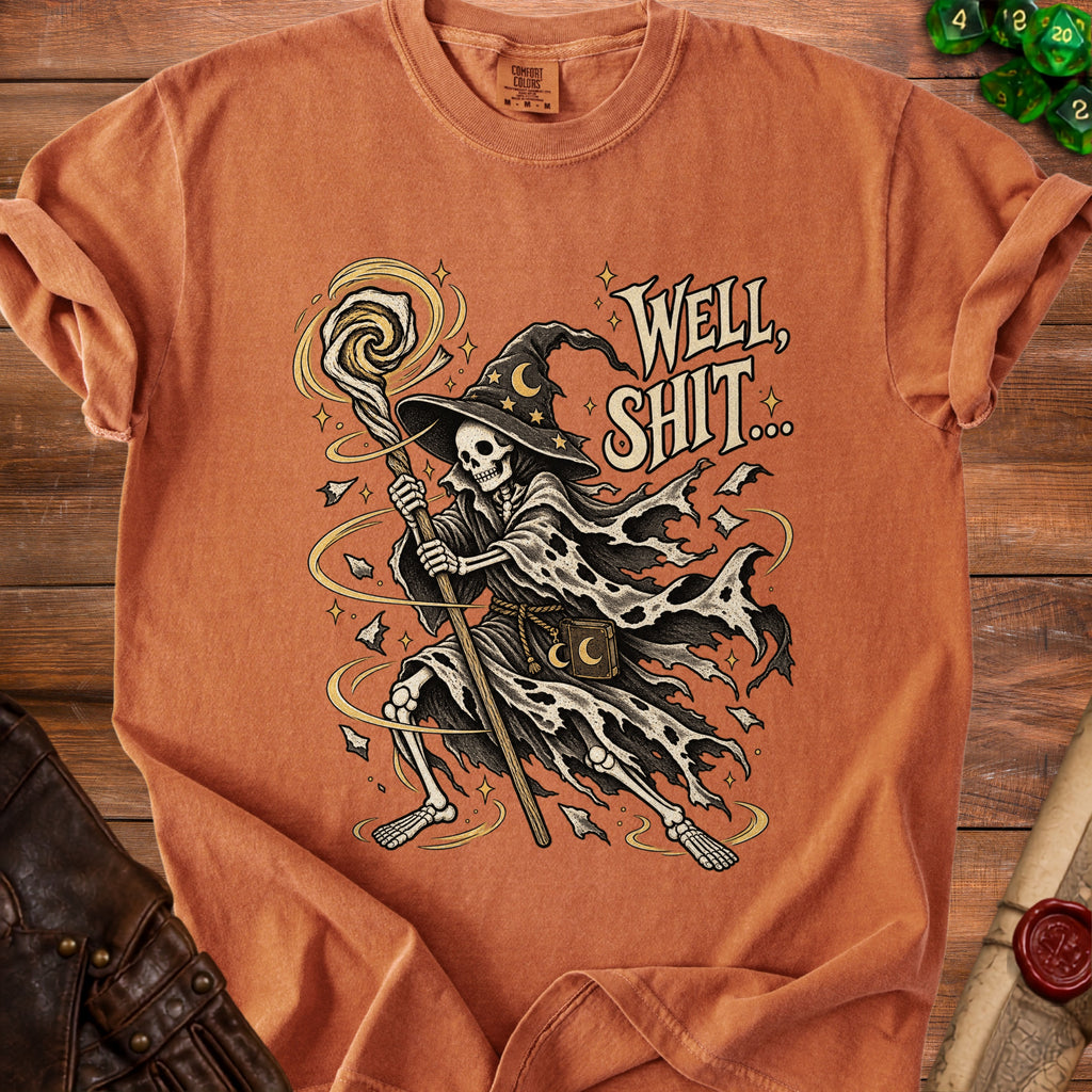 Skeleton wizard with staff and spell text "WELL, SHIT..." on an orange t-shirt.