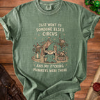 Green t-shirt graphic featuring a gnome and monkeys at a circus with text.