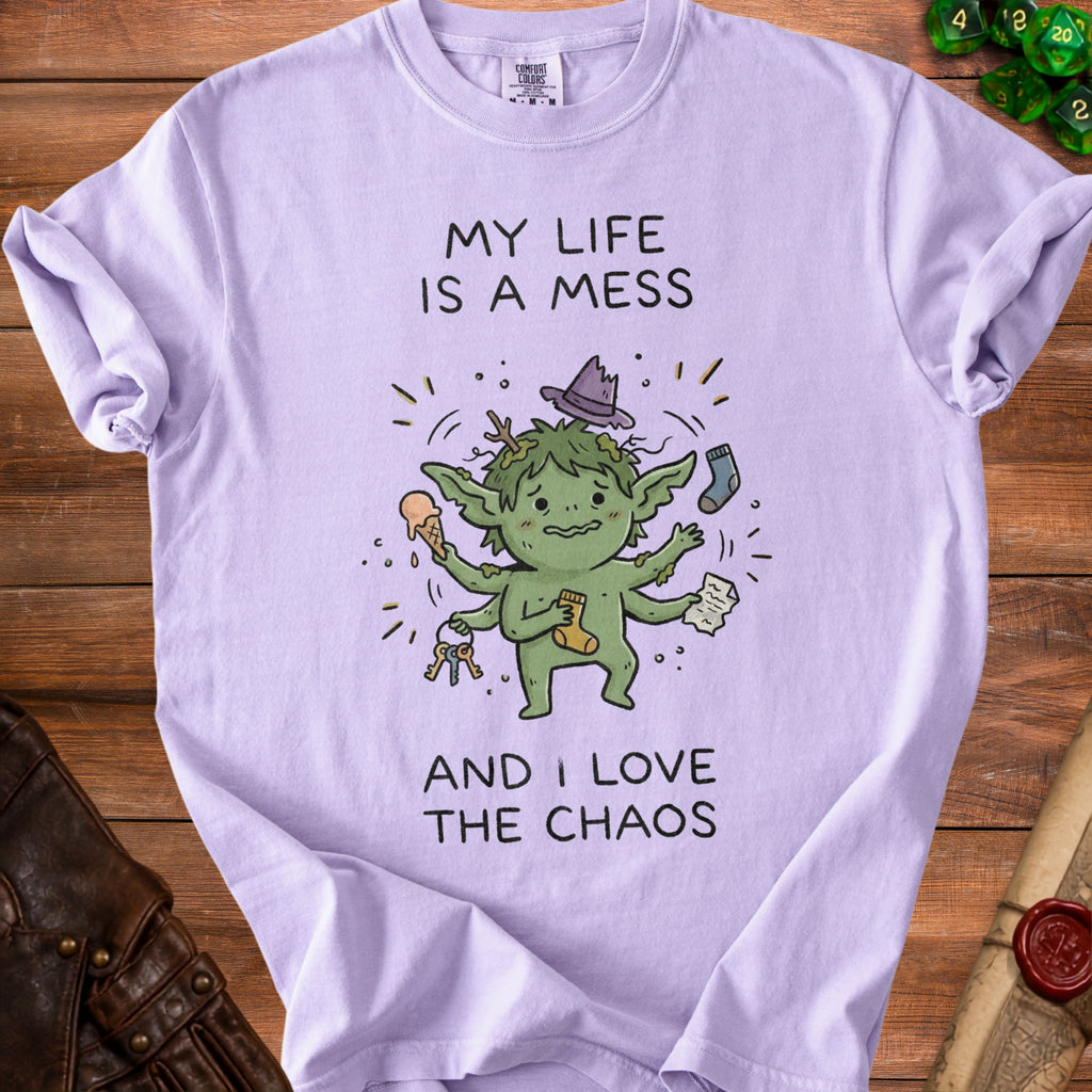 Lilac t-shirt with a cartoon goblin holding keys and a sock, saying "My life is a mess and I love the chaos."