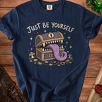 Navy t-shirt with "Just Be Yourself" text and a monster treasure chest graphic.