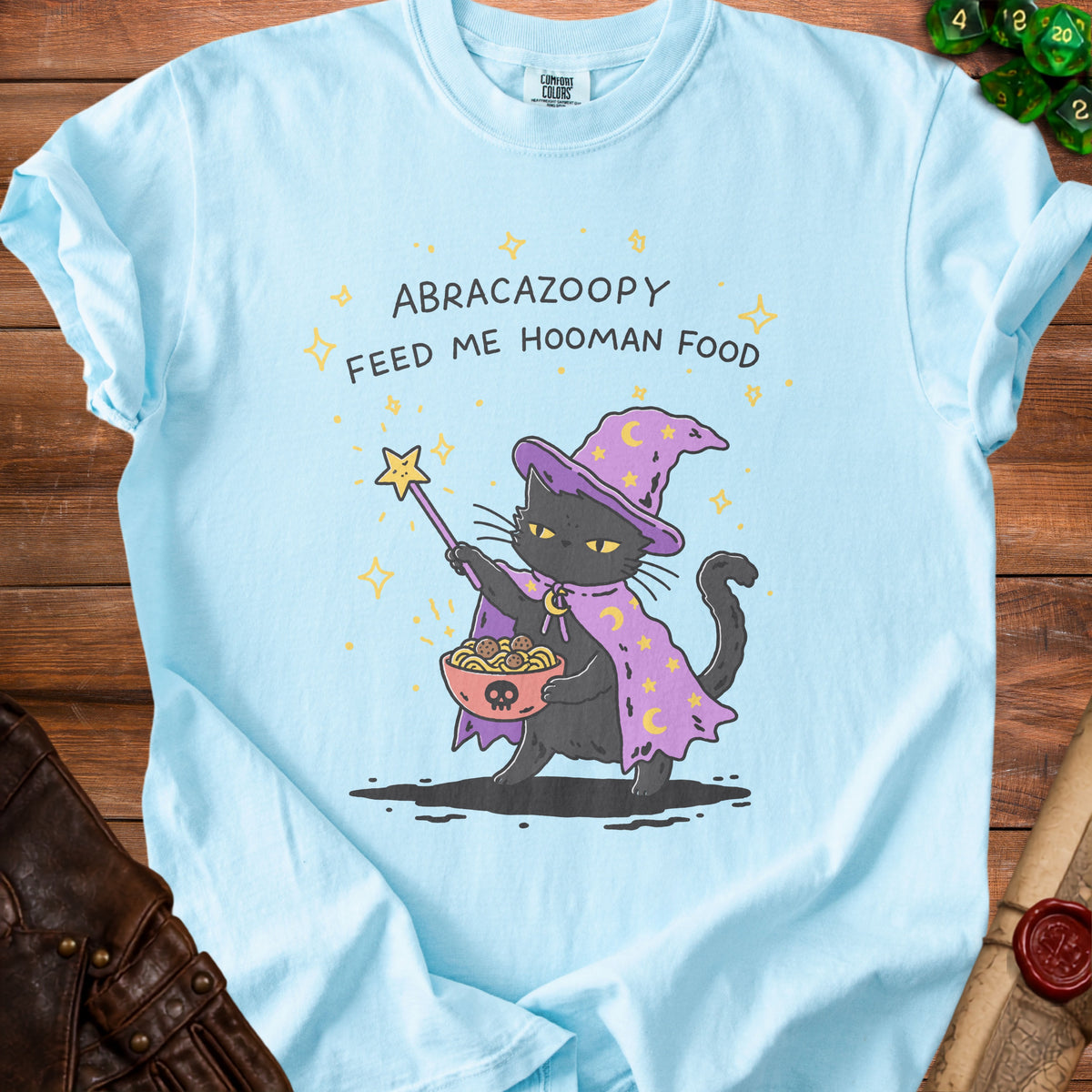Light blue t-shirt with wizard cat holding spaghetti and meatballs, text "ABRACAZOOPY FEED ME HOOMAN FOOD".