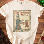 Cream t-shirt with a medieval-style graphic of a wizard and goblin holding a jar with a devil.