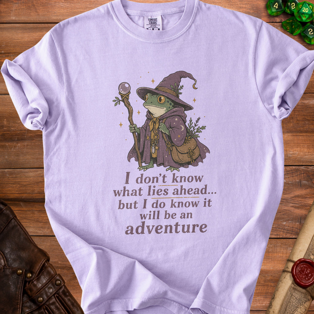 Lilac t-shirt with wizard frog graphic and "I don't know what lies ahead... but I do know it will be an adventure" text.