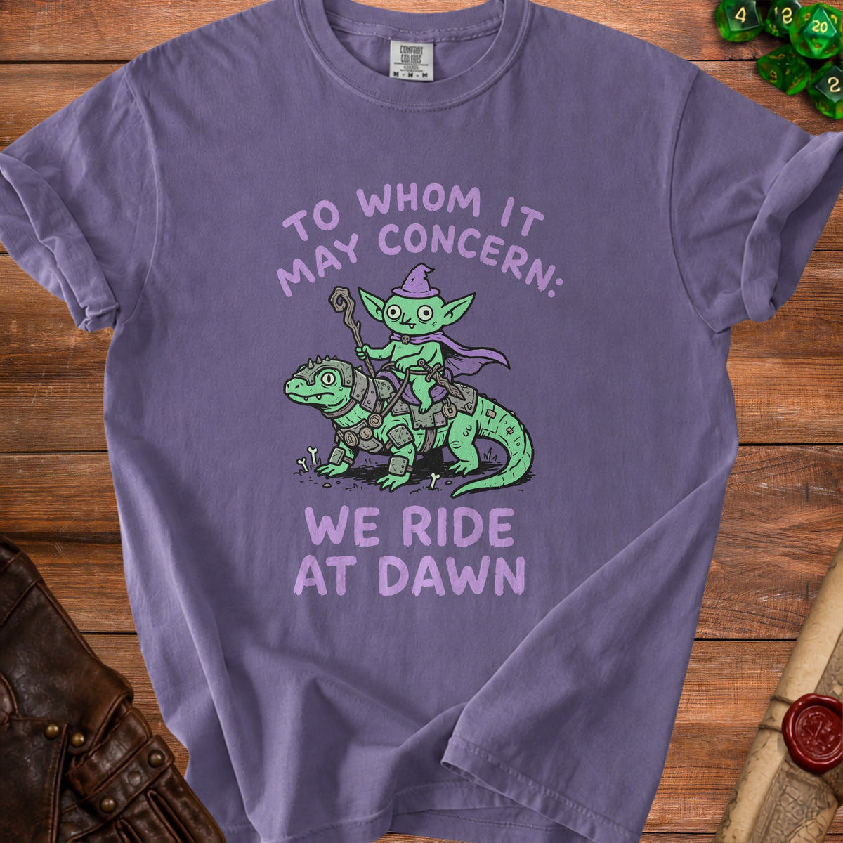 Purple t-shirt with cartoon goblin riding armored lizard, text "To Whom It May Concern: We Ride At Dawn."
