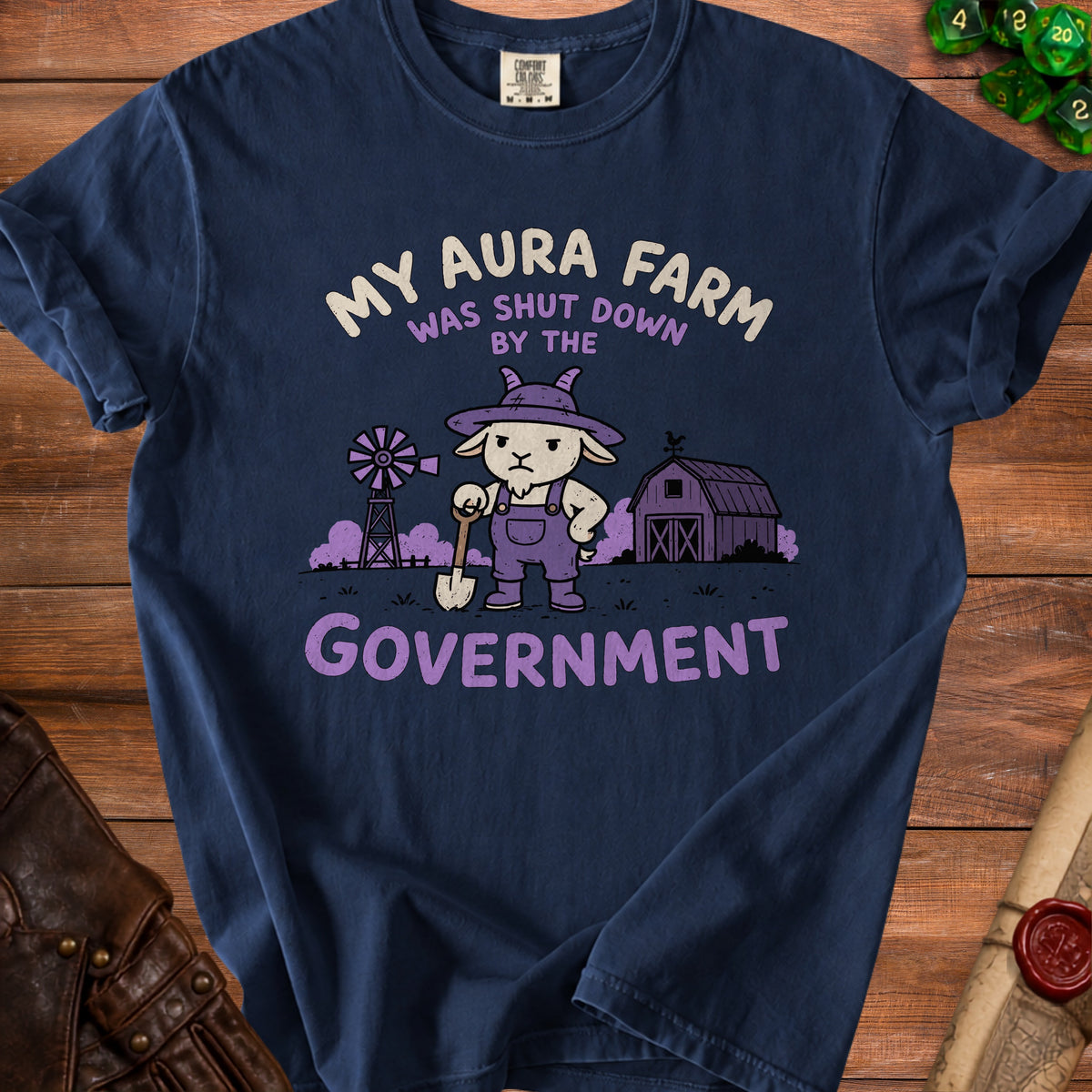 T-shirt with graphic of a goat holding a shovel, barn, and windmill with text.
