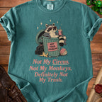 T-shirt with raccoon in trash can, "Not Your Problem" sign, and text "Not My Circus, Not My Monkeys, Definitely Not My Trash."