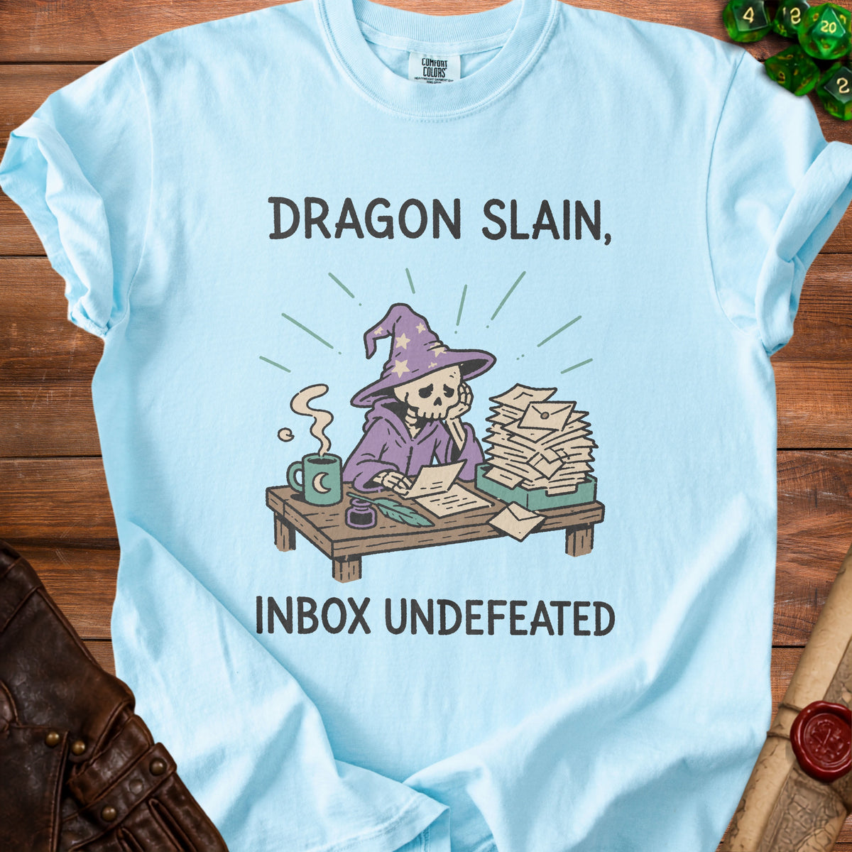Light blue t-shirt with skeleton wizard graphic and text "Dragon Slain, Inbox Undefeated".