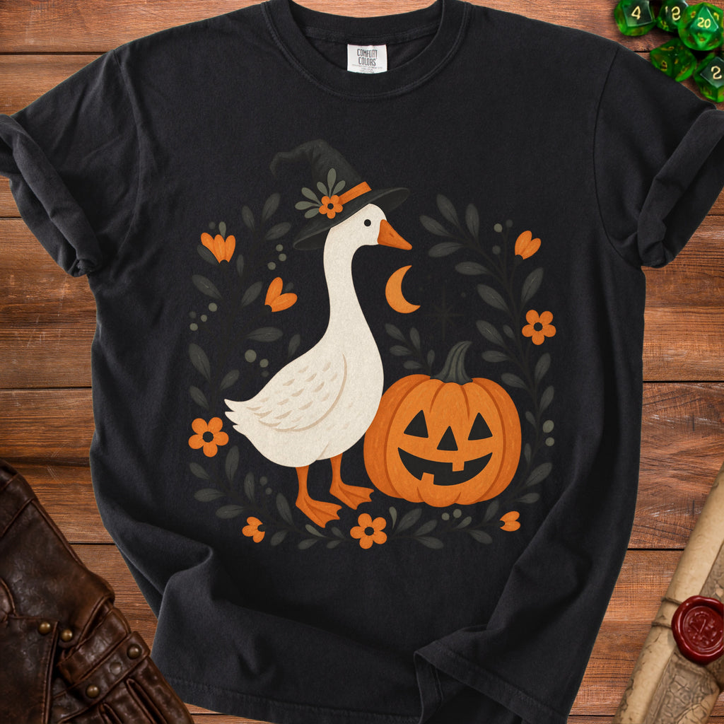 Black t-shirt with a goose wearing a witch hat, next to a pumpkin.