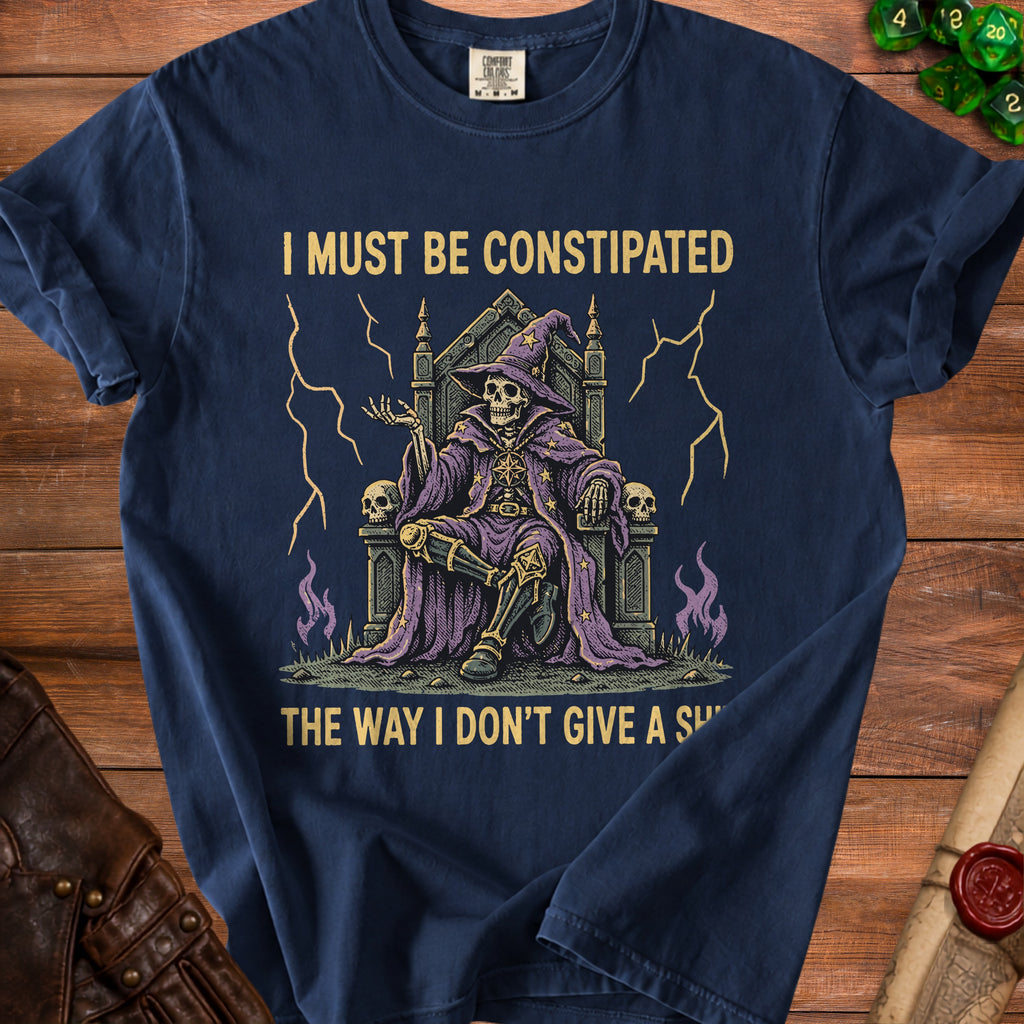 Dark navy t-shirt with skeleton wizard graphic and text: I MUST BE CONSTIPATED THE WAY I DON'T GIVE A S*.