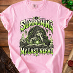 Pink t-shirt with a green and black occult graphic reading Summoning My Last Nerve.