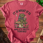 Red t-shirt with illustration of grumpy goblin holding coffee and text "It is what it is and it's pretty terrible."