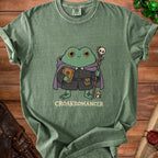 Green t-shirt with a cartoon frog wizard holding a book and staff, text reads "CROAKROMANCER".