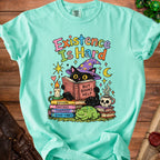 Black cat in wizard hat reads "Existence Is Hard But Books Help" with frogs and dice.
