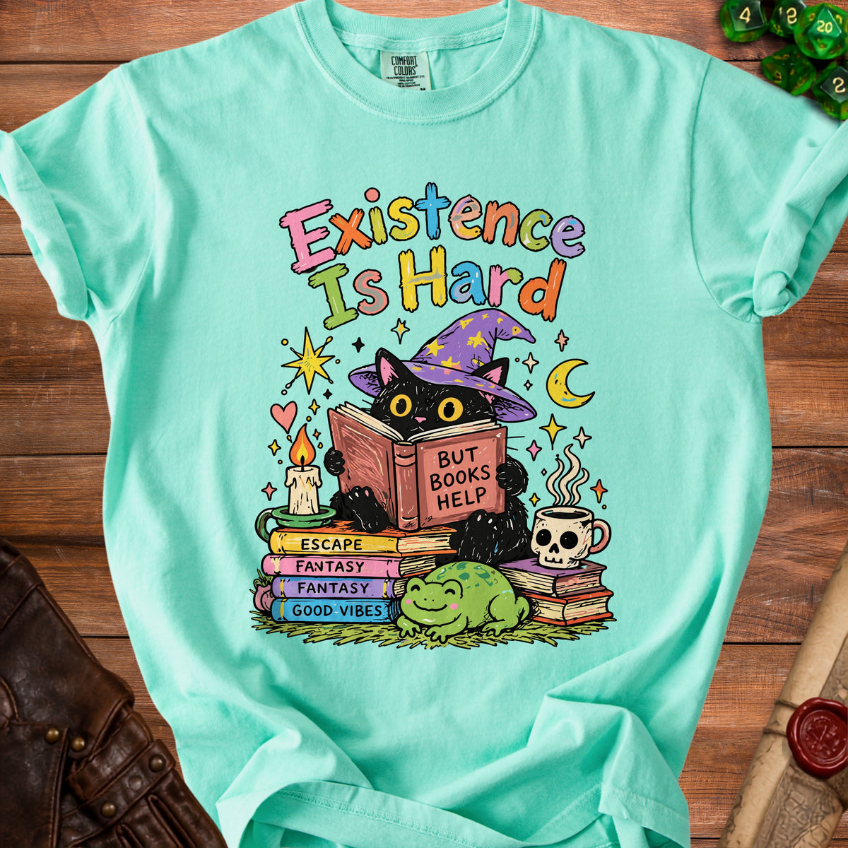 Black cat in wizard hat reads "Existence Is Hard But Books Help" with frogs and dice.