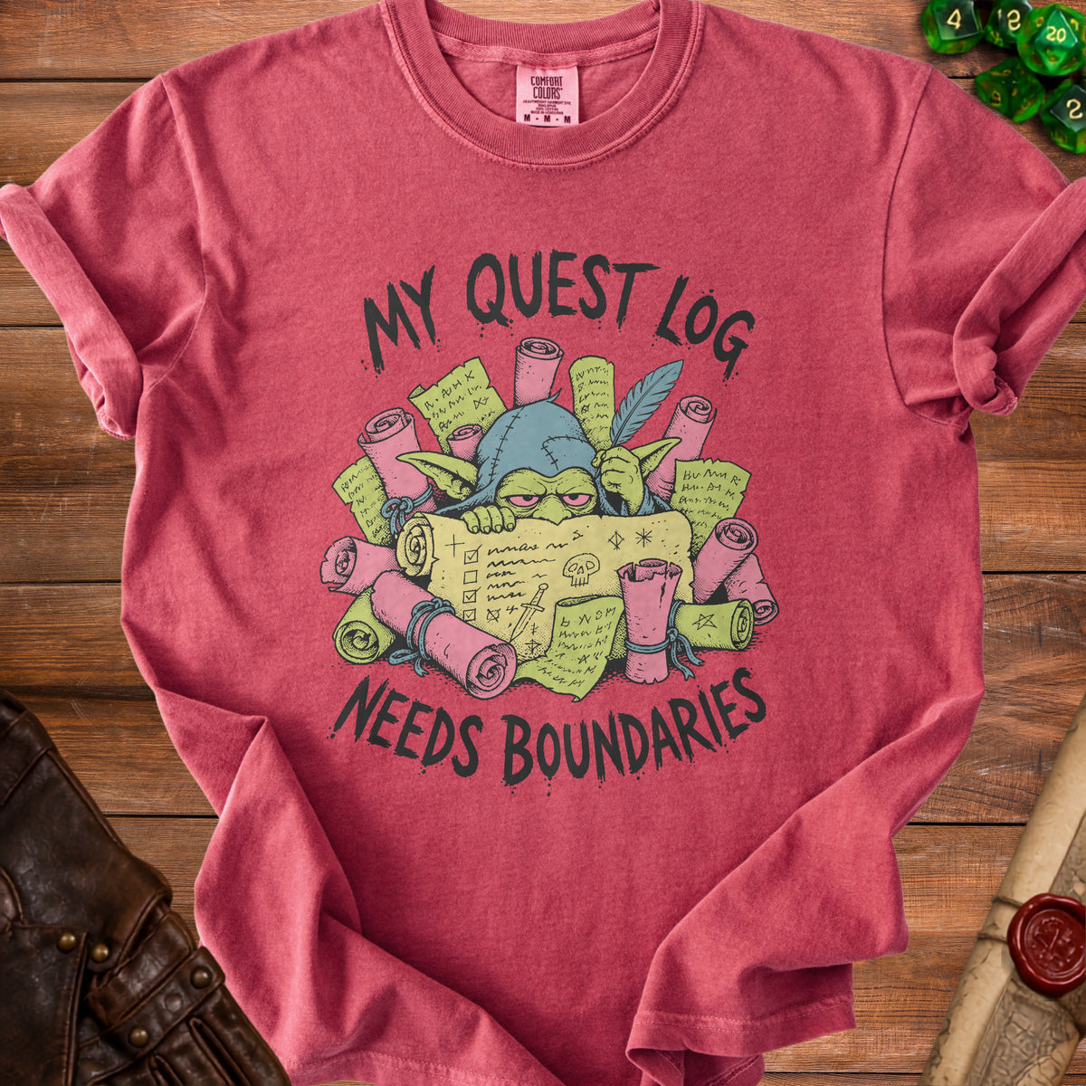 Red t-shirt with a cartoon goblin surrounded by scrolls and the text "My Quest Log Needs Boundaries."