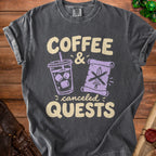 Dark grey t-shirt with "Coffee & canceled QUESTS" text, iced coffee, and crossed sword on scroll.
