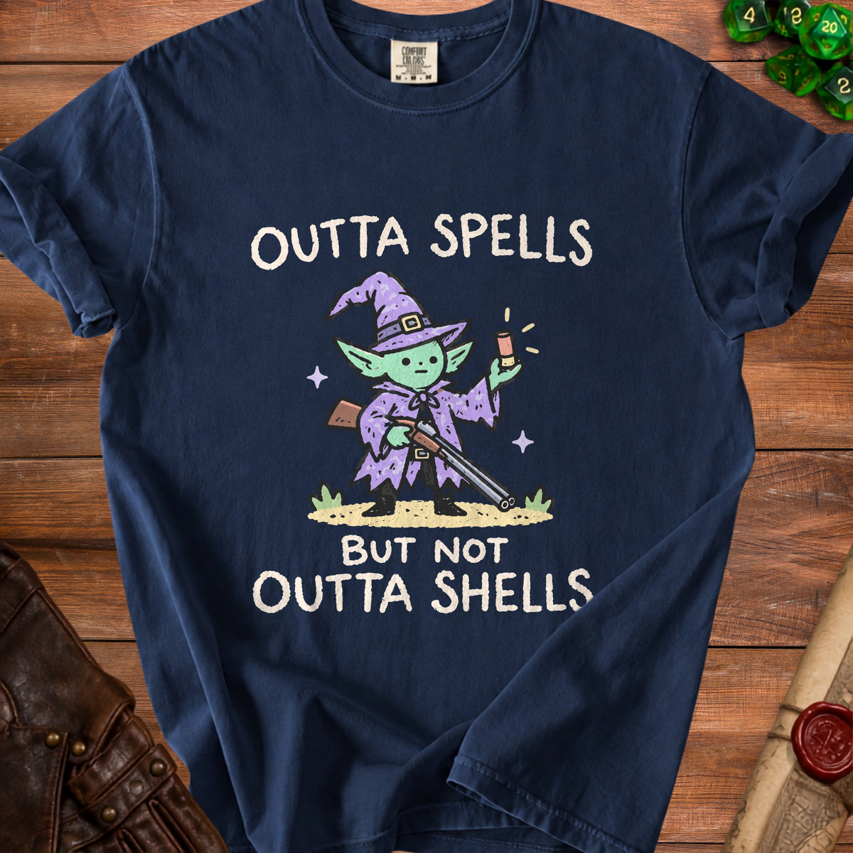 Navy t-shirt with a cartoon witch holding a shotgun and text reading "OUTTA SPELLS BUT NOT OUTTA SHELLS".