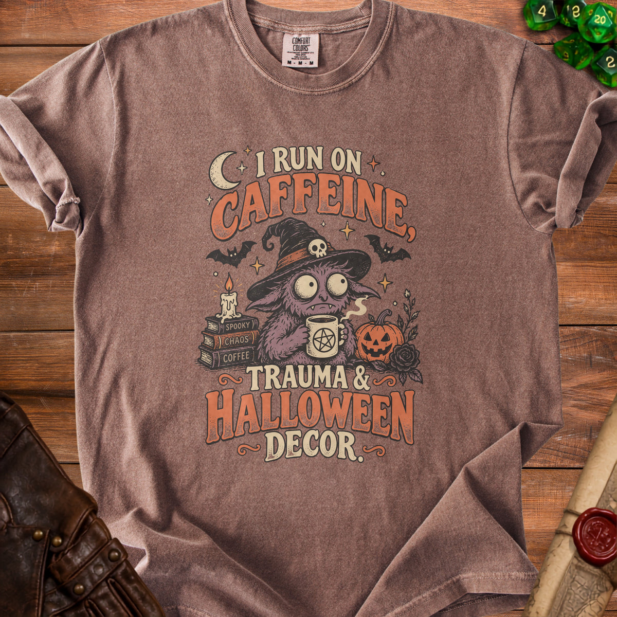 Brown t-shirt with cartoon monster saying "I run on caffeine, trauma & Halloween decor."