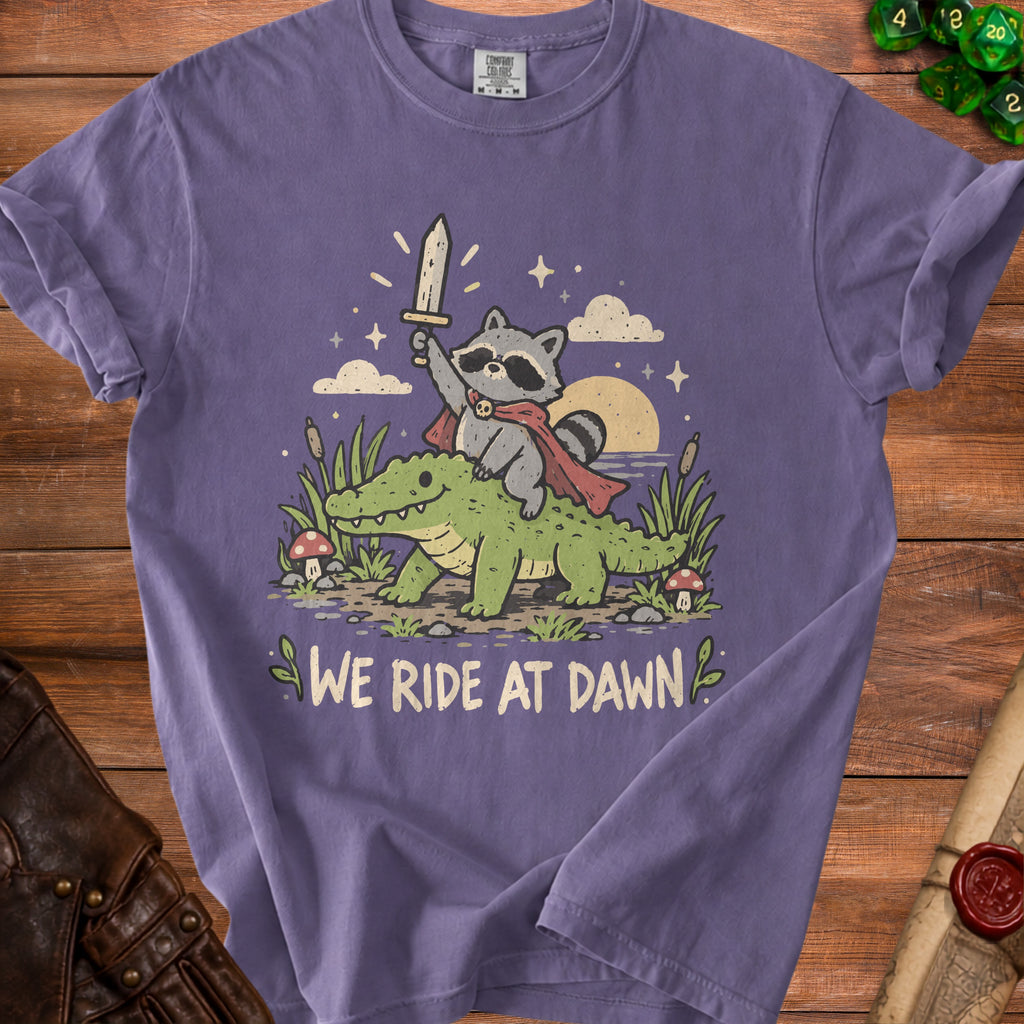 Raccoon with sword riding alligator, text "WE RIDE AT DAWN"
