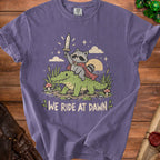 Raccoon with sword riding alligator, text "WE RIDE AT DAWN"