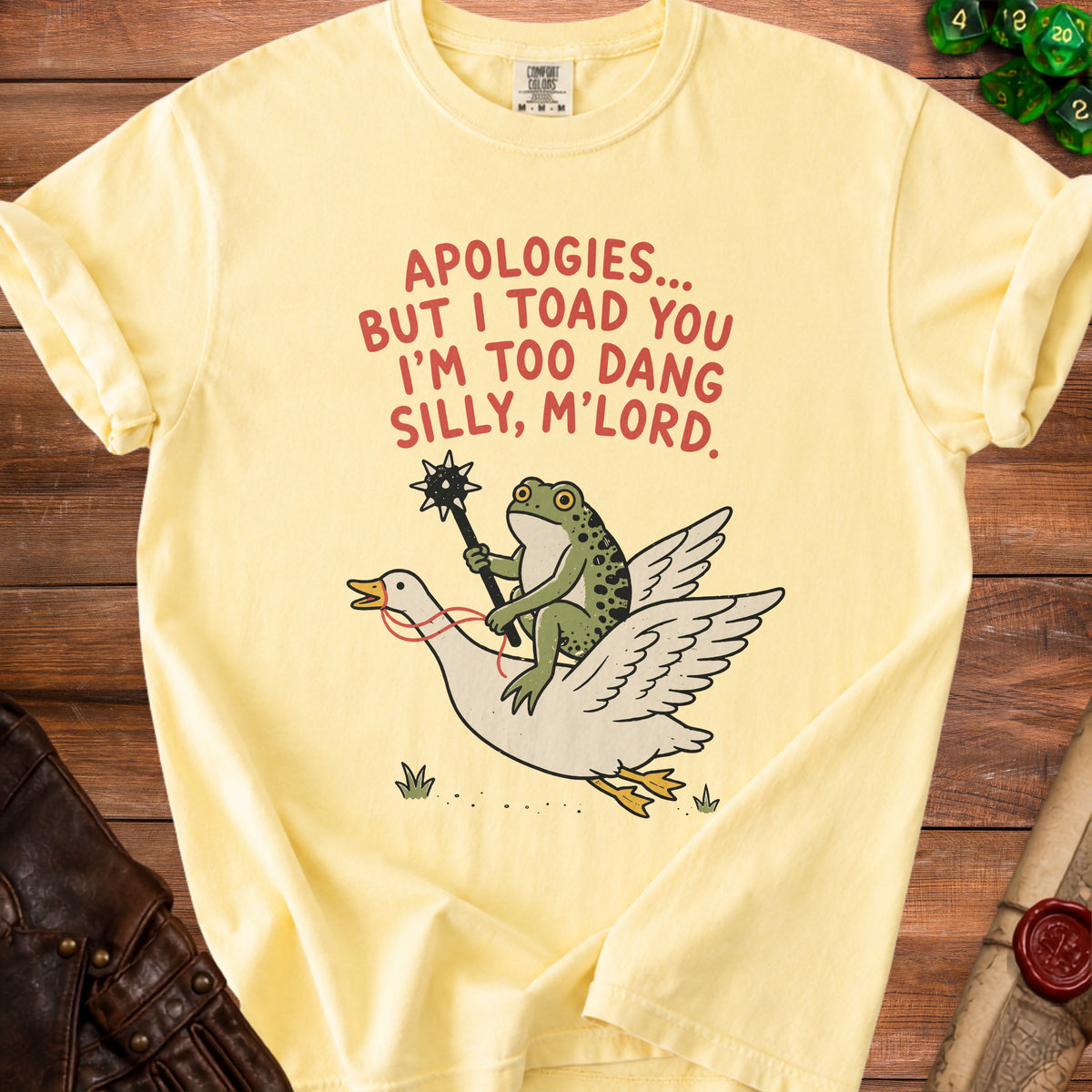 Yellow t-shirt with cartoon frog riding a goose, text "APOLOGIES... BUT I TOAD YOU I'M TOO DANG SILLY, M'LORD."