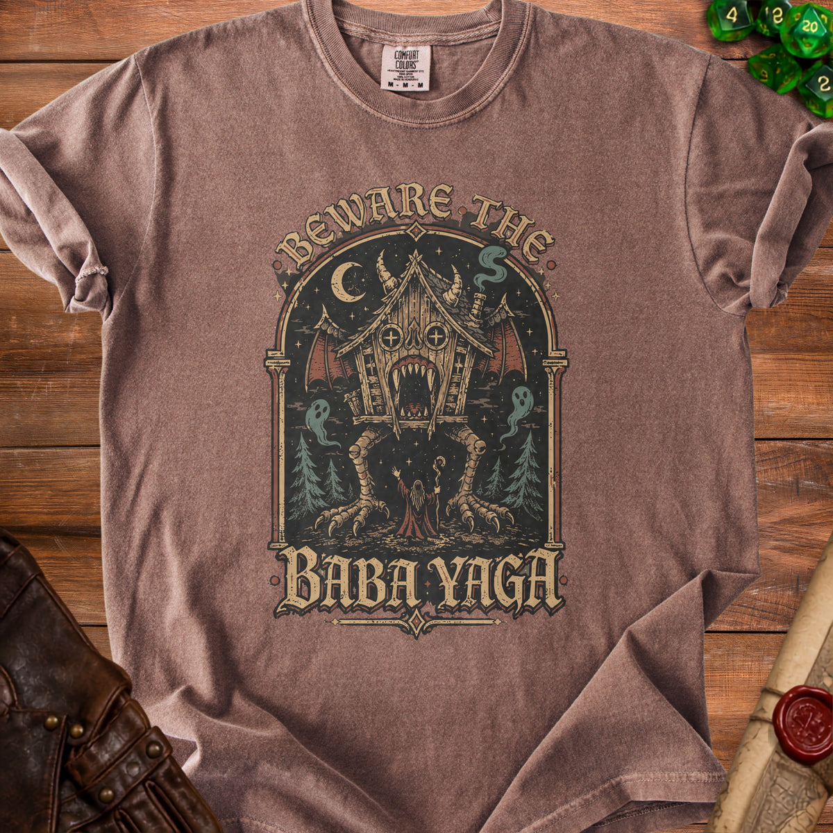 T-shirt with "Beware the Baba Yaga" design featuring a haunted house on chicken legs.