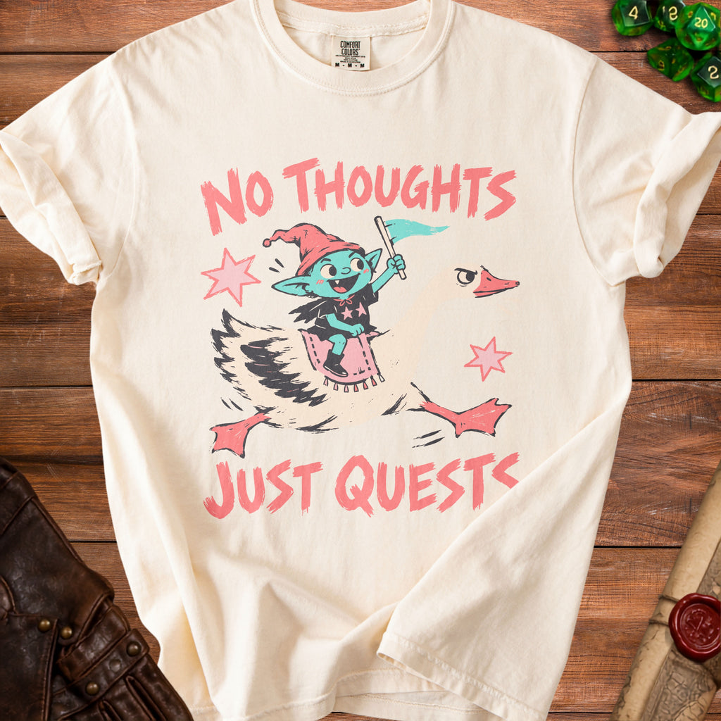 Cream t-shirt with a goblin riding a goose graphic and text "NO THOUGHTS JUST QUESTS".