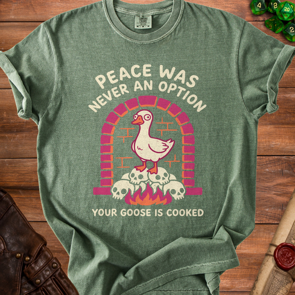 Green t-shirt with a goose on skulls and flames graphic.