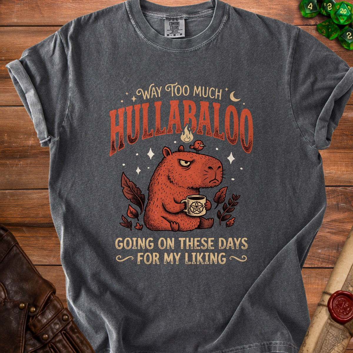 Charcoal t-shirt with a capybara, occult mug, and text: "Way Too Much Hullabaloo Going On These Days For My Liking."