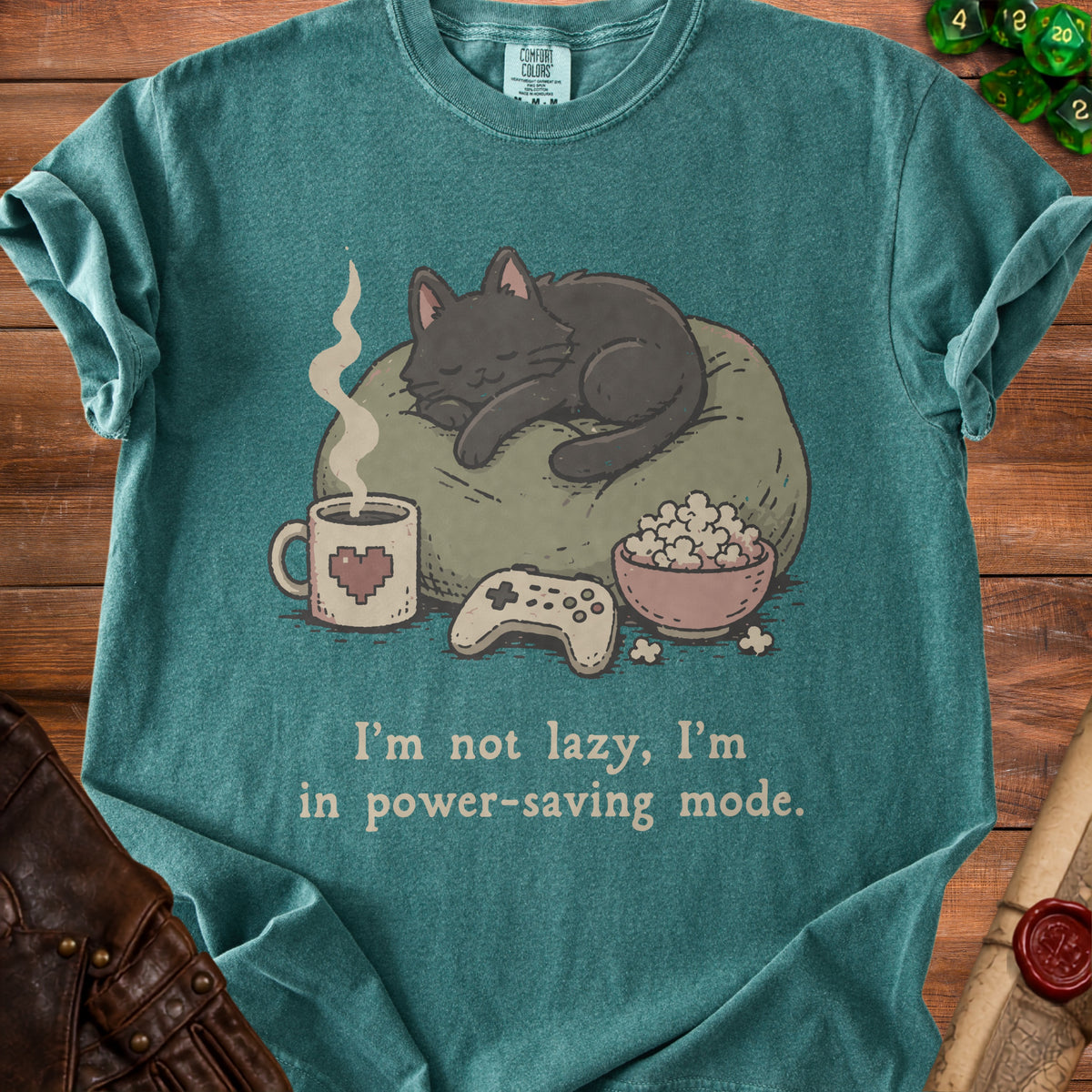 Green t-shirt with a sleeping cat, coffee, popcorn, and controller. Text reads "I'm not lazy, I'm in power-saving mode."