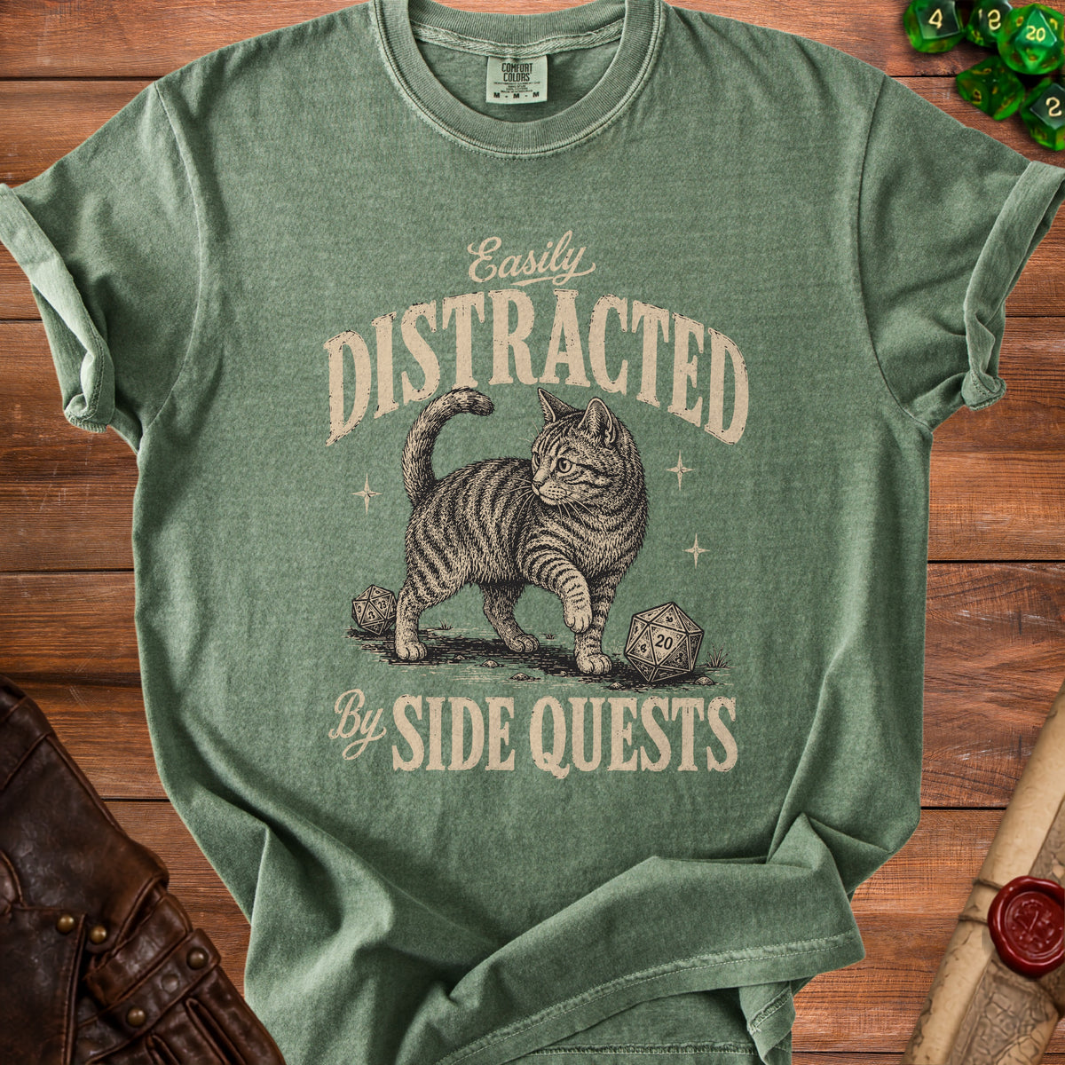 Green t-shirt with a drawing of a cat and dice, reading "Easily Distracted By Side Quests".