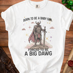 White t-shirt with knight graphic and text "Born to be a baby girl forced to be a big dawg."
