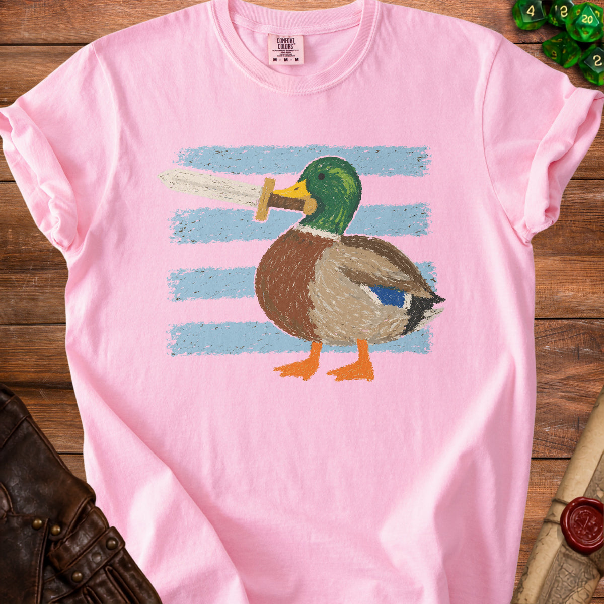 Pink t-shirt with a cartoon duck holding a sword, on a striped background.