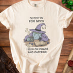 Cream t-shirt with a wizard holding a coffee cup and text "Sleep is for NPCs I Run on Chaos and Caffeine".