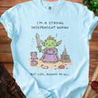 Light blue t-shirt with a cartoon goblin holding a sword and text "I'M A STRONG INDEPENDENT WOMAN BUT LIKE, AGAINST MY WILL."