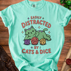 Mint t-shirt with a green cat and dice graphic saying "Easily Distracted By Cats & Dice".