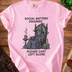 Pink t-shirt with skeleton wizard graphic and text "SOCIAL BATTERY DRAINED PLEASE CAST LEFT ALONE".