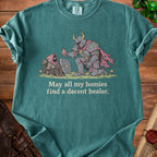T-shirt graphic of knight offering potion to hooded figure with text "May all my homies find a decent healer."