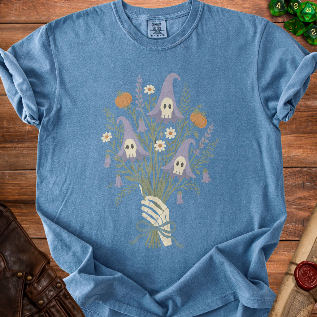 Skeleton hand holding a bouquet of witch hats with skulls, pumpkins, and flowers.